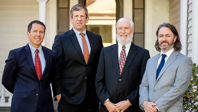 Georgia Social Security Disability lawyers from Silver & Archibald, Patrick Cates, Michael Keene, Kent Silver and Ben Walters, stand in front of one of the firm's offices in Athens.