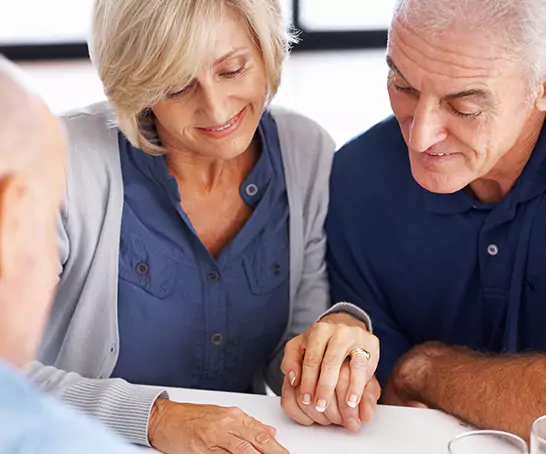 A woman and man sit at a table reviewing paperwork, her hand on his. The Georgia Social Security lawyers at Silver & Archibald are both highly skilled and deeply caring as they help you get Social Security Disability benefits