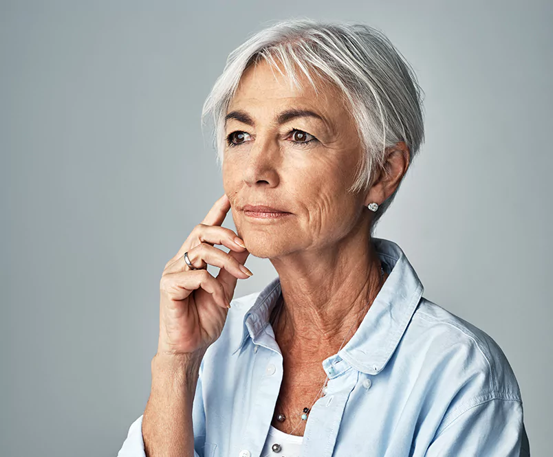 A stock photo of an older woman contemplating.