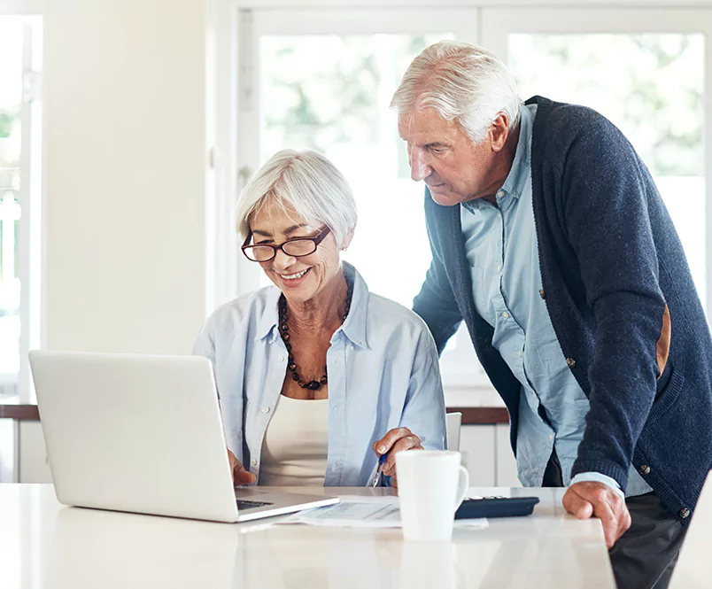 An older couple looking at a laptop screen together